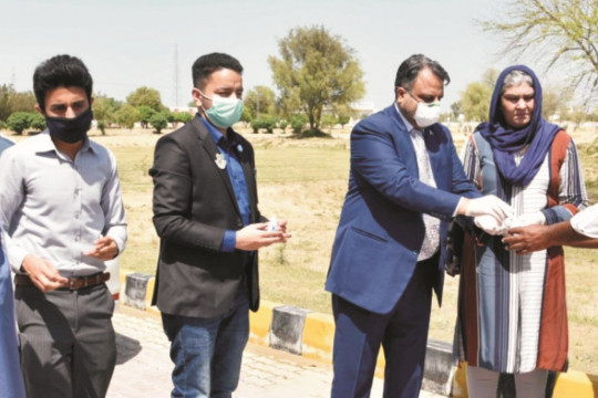 Worthy Vice Chancellor distributing hand sanitizers among on duty employees